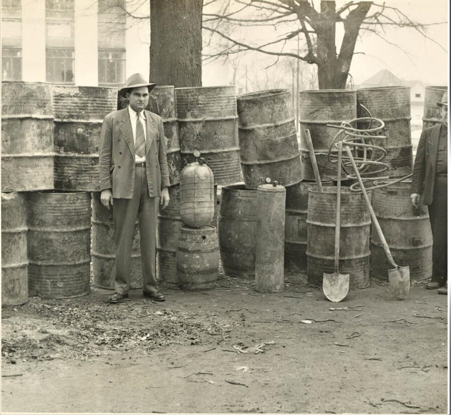 Lawman beside a confiscated whiskey still